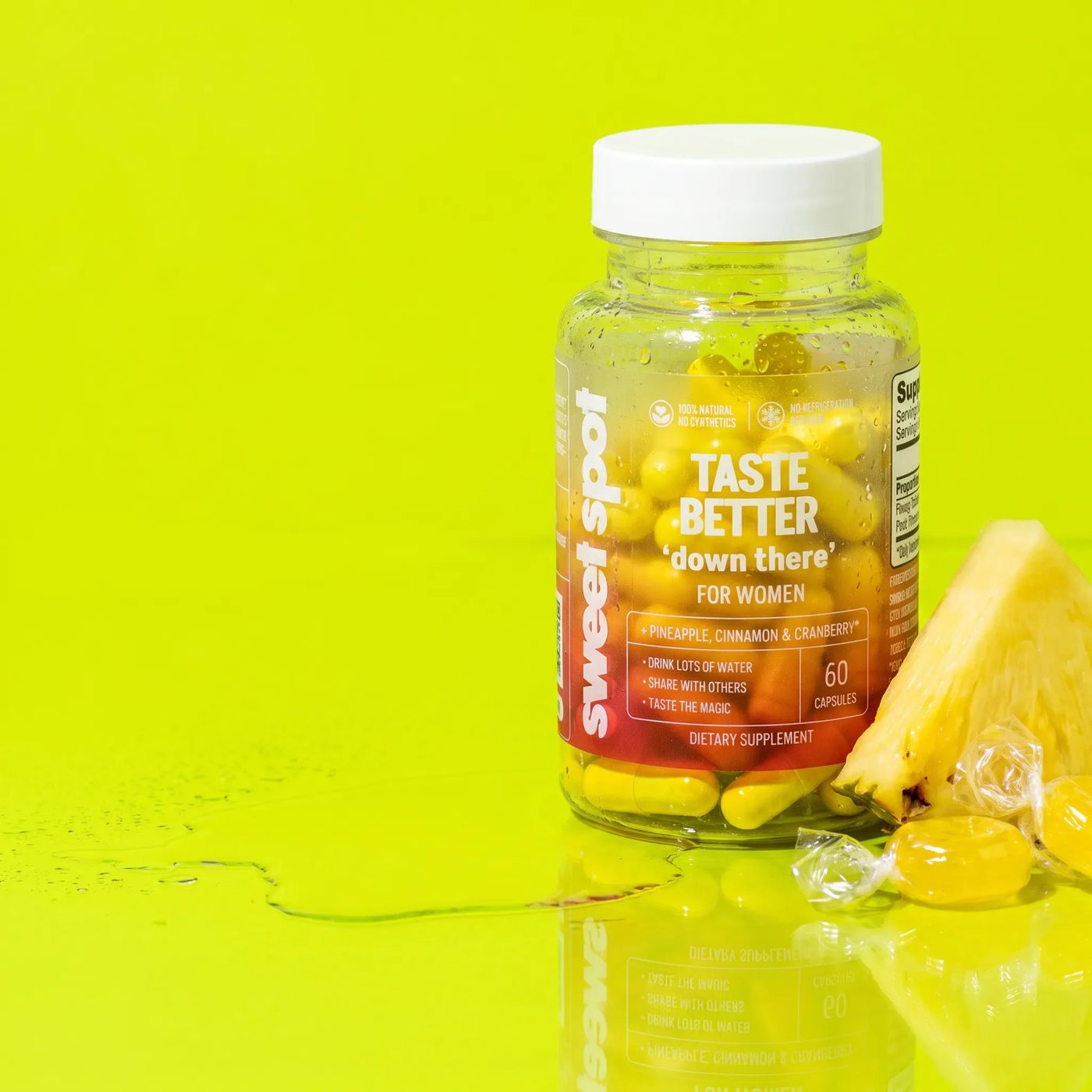 Taste Better bottle on a lime table beside a pineapple wedge and pineapple candy.